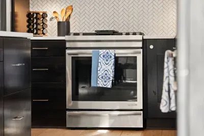 Full kitchen with quartz countertops, open to living and dining areas, island seating for 5. Kitchen is stocked with coffee, coffee maker (drip), basic seasonings, pots, pans, serveware, dishes, utensils, and kitchen appliances small and large!