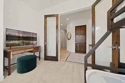 Bedroom 5: Twin over queen bunk bed located in the den off of the main foyer on the downstairs level. Dresser, smart TV, and closet in room along with children's books and toys.