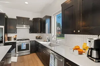 Full kitchen with quartz countertops, open to living and dining areas, island seating for 5. Kitchen is stocked with coffee, coffee maker (drip), basic seasonings, pots, pans, serveware, dishes, utensils, and kitchen appliances small and large!