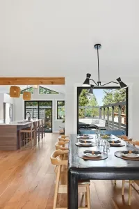 Bright open kitchen & dining with deck access and forest views