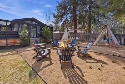Backyard oasis with fire pit, Adirondack seating, teepees & swing set.