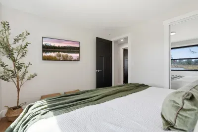 Bright modern bedroom with cozy linens and calming green accents