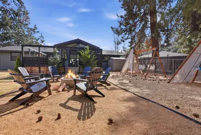 Cozy fire pit, Adirondacks, and kid-friendly swings under tall pines