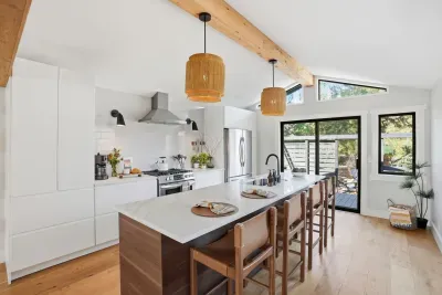 Bright chef’s kitchen with island, bar seating & patio access