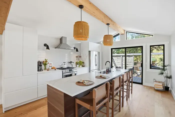 Bright chef’s kitchen with island, bar seating & patio access