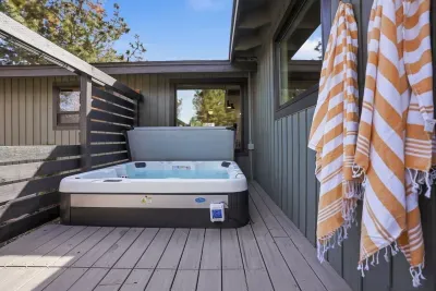 Private deck with hot tub, plush towels, and serene treetop views