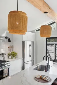 Bright modern kitchen with quartz island, stainless appliances, and warm pendants