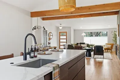 Bright open-concept living with quartz island, wood beams, and chic lounge