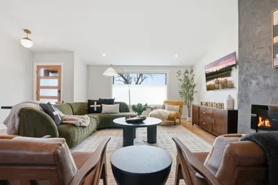 Bright modern lounge with fireplace, plush seating, and big window