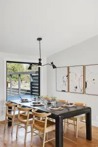 Sunlit dining room for 8 with modern table, art, and scenic window views.