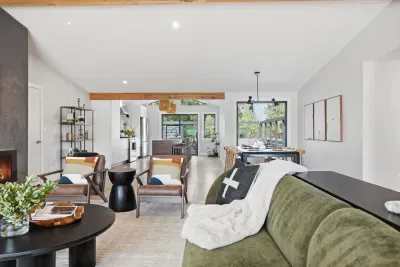 Bright open-plan living with fireplace, island kitchen, and dining patio view.