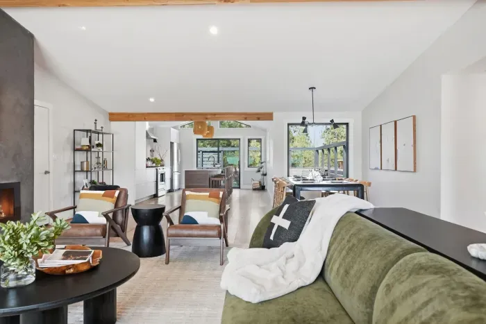 Bright open-plan living with fireplace, island kitchen, and dining patio view.