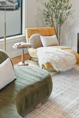 Sunlit lounge with curved sofa, mustard chaise & cozy textures