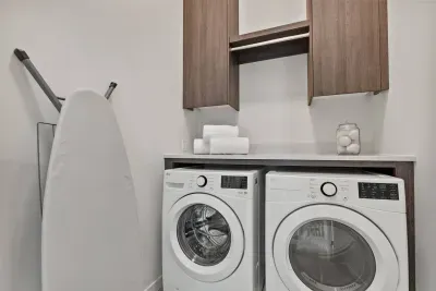 Laundry room is modern and efficient. Detergent is provided along with dryer balls, ironing board, iron, and extra linens.