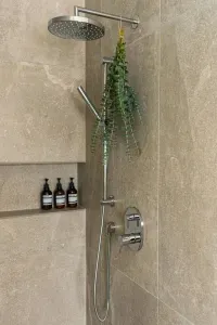 Primary bathroom: Luxury is the best way to describe this room. Curbless, walk-in shower framed with custom glass, heated floors throughout, dual sink and smart mirror with settings for daylight, makeup, or natural lighting, and private toilet room