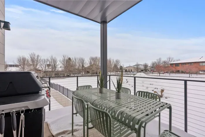 Another balcony outfitted with a dining table and natural gas BBQ, all covered so you can enjoy year-round
