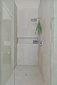 Primary bathroom: Luxury is the best way to describe this room. Curbless, walk-in shower framed with custom glass, heated floors throughout, dual sink and smart mirror with settings for daylight, makeup, or natural lighting, and private toilet room