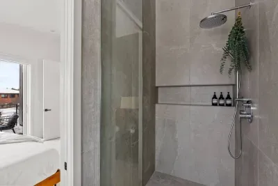 Primary bathroom: Luxury is the best way to describe this room. Curbless, walk-in shower framed with custom glass, heated floors throughout, dual sink and smart mirror with settings for daylight, makeup, or natural lighting, and private toilet room