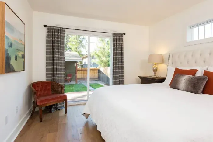 Primary room with large shared primary ensuite bathroom and access to back deck