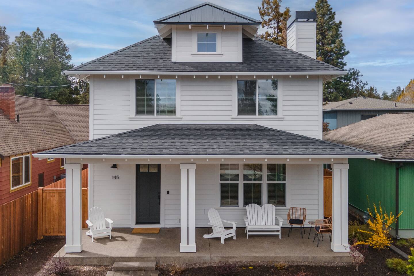 Charming two-story home with a spacious covered porch and inviting seating