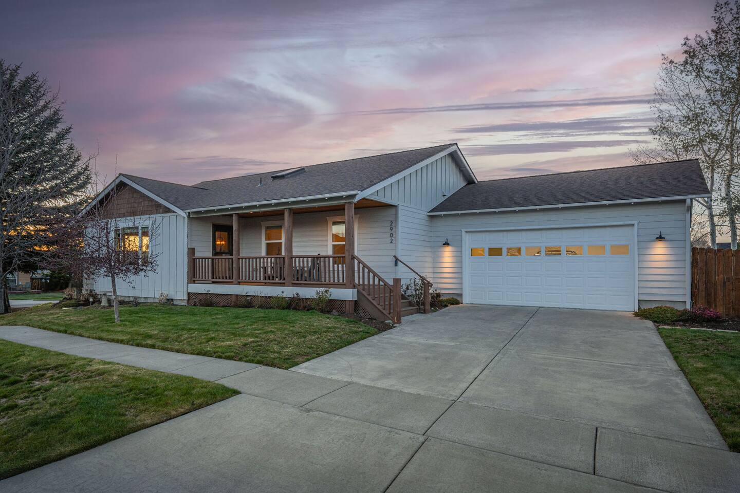 Inviting single-level home with porch, garage, and sunset curb appeal