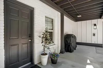 Chic covered entry with grill, keypad access, and modern lighting