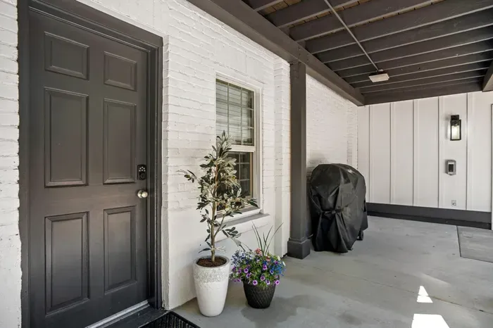 Chic covered entry with grill, keypad access, and modern lighting