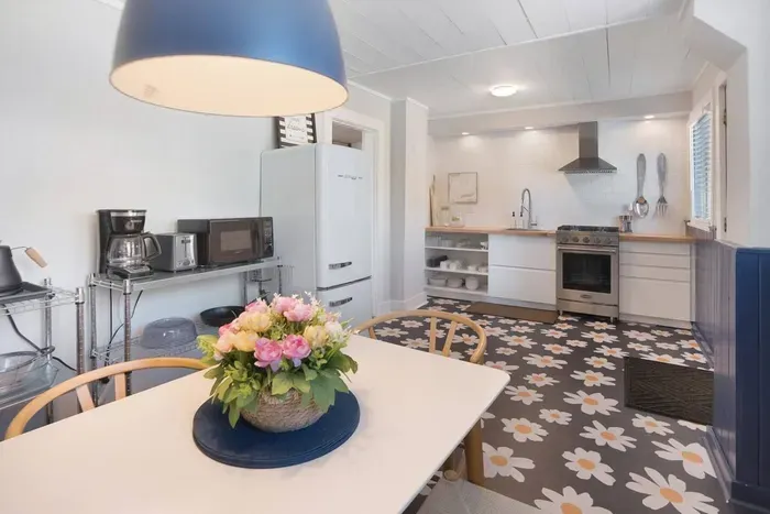 Bright designer kitchen with retro charm, floral floors, and cozy dining space