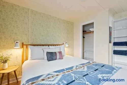Cozy, bright bedroom with soft lighting, open closet, and fresh linens