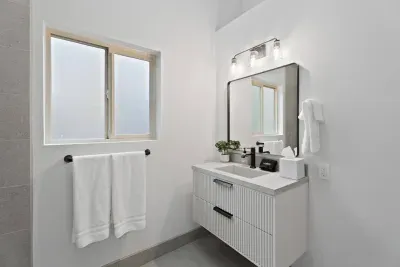 Bright modern bathroom with sleek vanity, matte black accents, and natural light