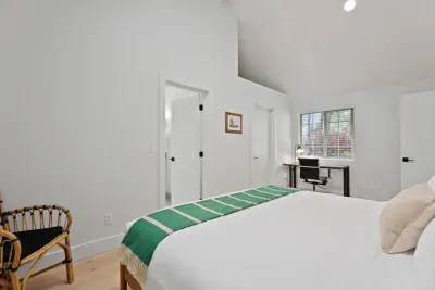 Bright vaulted bedroom with workspace and serene modern style