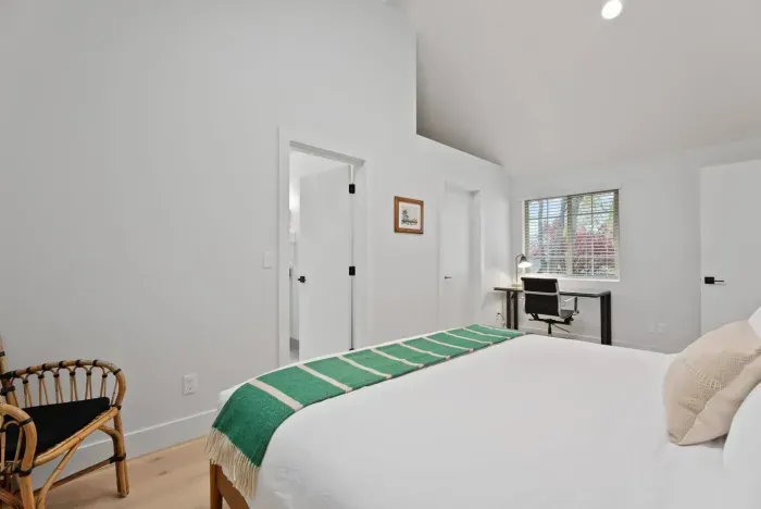 Bright vaulted bedroom with workspace and serene modern style