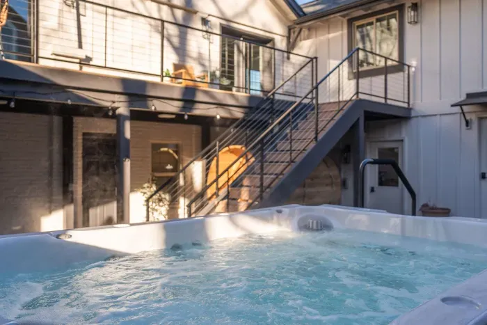 Private courtyard with hot tub, balcony lounge, and sauna retreat