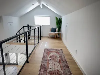 Bright loft hallway with vaulted ceilings and a cozy window-side nook