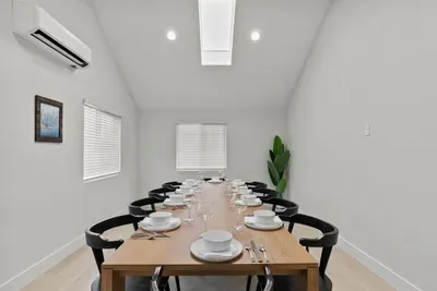 Bright vaulted dining room with skylight and seating for group meals