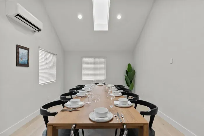 Bright vaulted dining room with skylight and seating for group meals