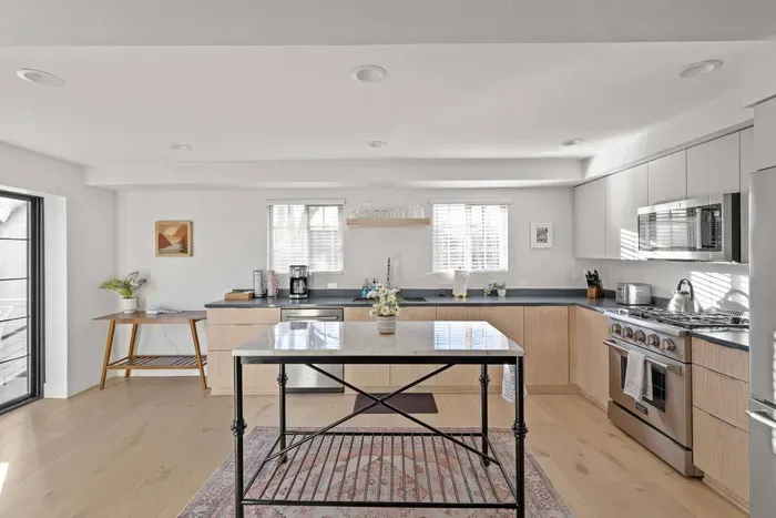 Bright modern kitchen with island, stainless appliances, and natural light