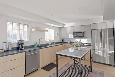 Bright modern kitchen with stainless appliances and marble-top island