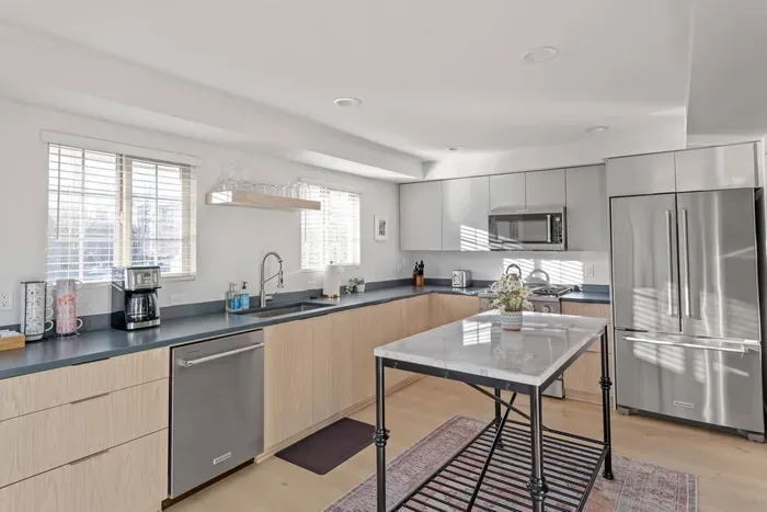 Bright modern kitchen with stainless appliances and marble-top island