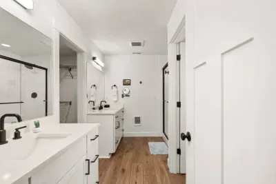 Bright modern bathroom with dual vanities and sleek glass shower