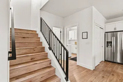 Bright modern entry with wood floors, sleek stairs, and updated finishes