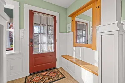 Bright entryway with built-in bench, mirror, and charming craftsman details