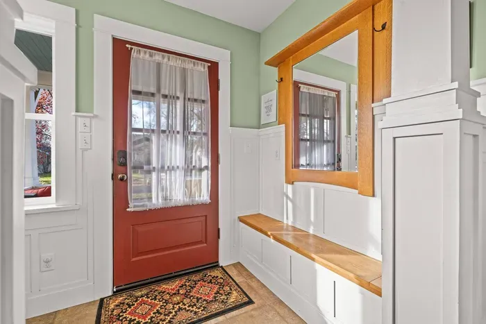Bright entryway with built-in bench, mirror, and charming craftsman details