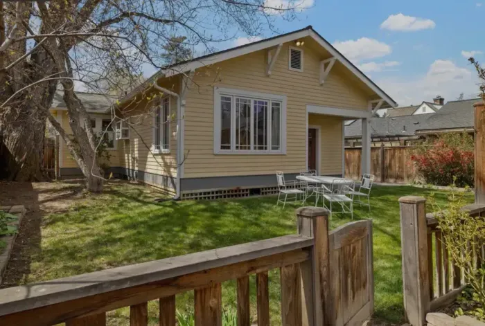Sunny fenced yard with bistro set—perfect for outdoor relaxing.