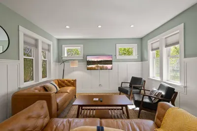Bright living room with leather sofas, natural light, and modern style