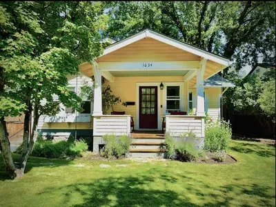 Charming bungalow with shaded porch seating and lush garden