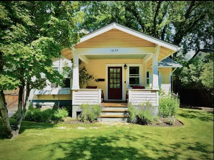 Charming bungalow with shaded porch seating and lush garden