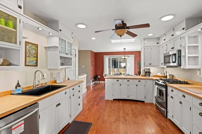 Bright gourmet kitchen with island, gas range, and abundant natural light