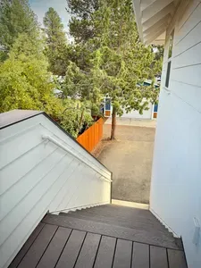 Private exterior entry with easy parking under tall pines and fencing