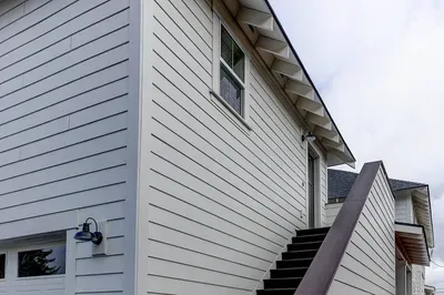 Private upstairs entry with modern siding and bright exterior lighting